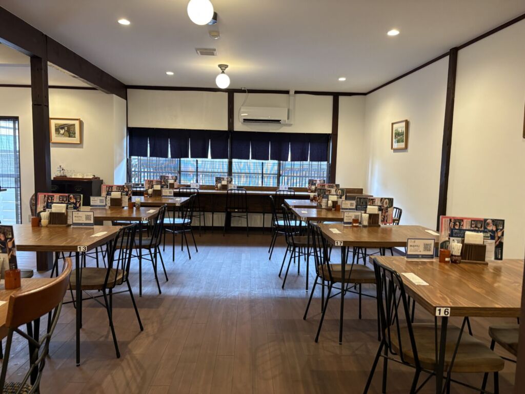 しまの音の店内。古民家を改修した空間に木のテーブル席が並び、開店直後で客がいない